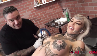 Блондинка мастурбирует пока мастер набивает ей тату